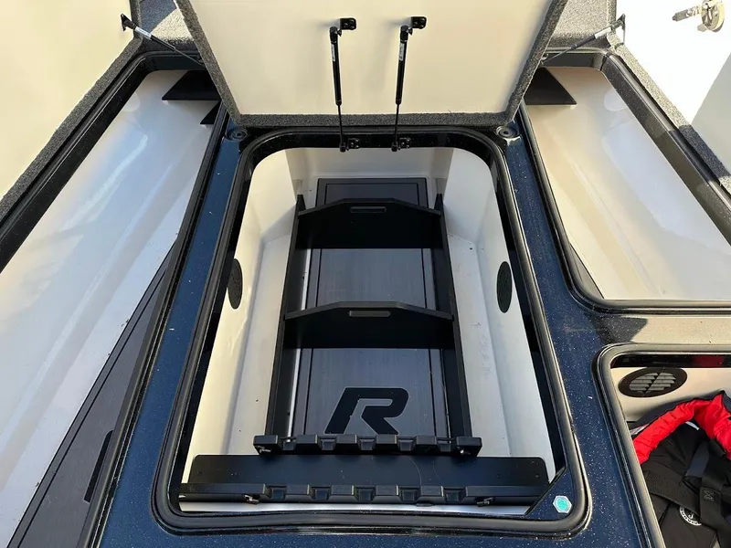 Slide: The Image of 2024 Ranger Z521R boat storage compartment with open lid and organized interior. - 23