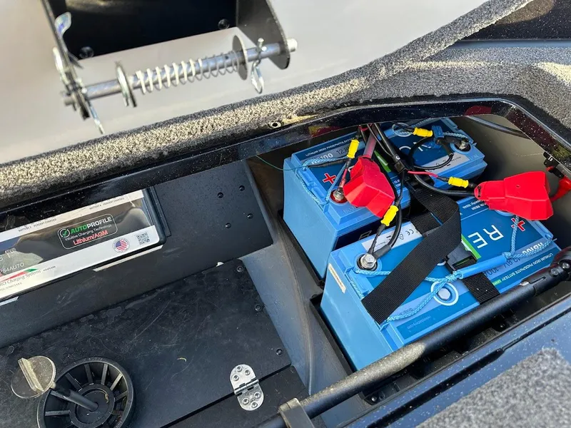Slide: The Image of 2024 Ranger Z521R boat battery compartment with blue batteries and wiring. - 34