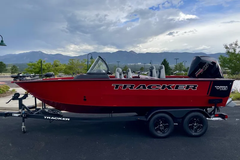 The Image of 2024 Tracker Targa V-19 WT boat in vibrant red on a trailer, scenic mountain backdrop. - 0