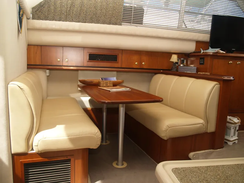 Slide: The Image of Interior of 2001 Cruisers 3750 yacht with beige seating and wooden table. - 10