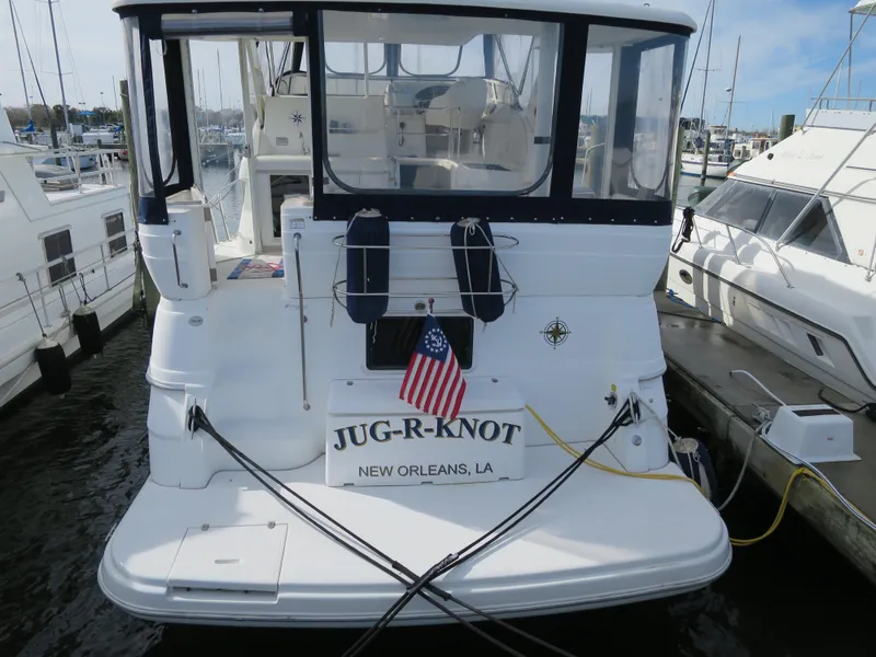 Slide: The Image of 2001 Cruisers 3750 yacht docked, named "JUG-R-KNOT," with American flag, New Orleans, LA. - 3