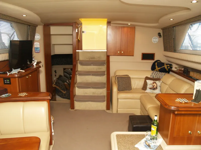 Slide: The Image of Interior of 2001 Cruisers 3750 yacht with beige seating and wooden accents. - 13
