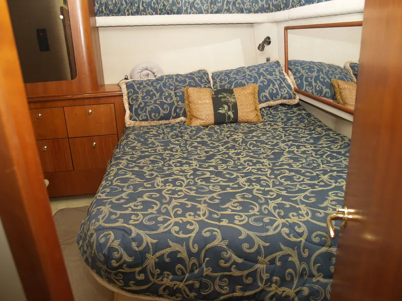 Slide: The Image of Luxurious cabin interior of 2001 Cruisers 3750 yacht with patterned bedding and wooden cabinetry. - 16