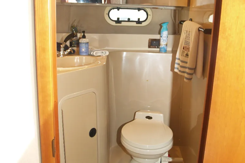 Slide: The Image of 2001 Cruisers 3750 yacht bathroom with toilet, sink, and window. - 17
