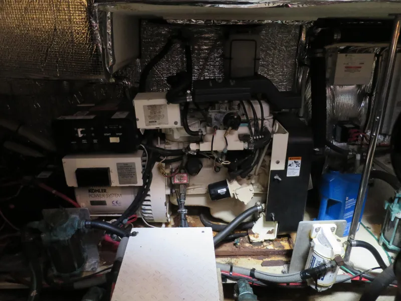 Slide: The Image of Engine room of a 2001 Cruisers 3750 yacht, featuring mechanical components and wiring. - 21