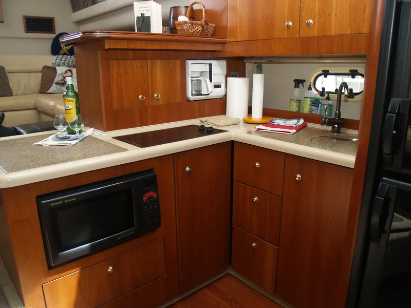 Slide: The Image of 2001 Cruisers 3750 yacht kitchen with microwave, sink, and wooden cabinetry. - 9