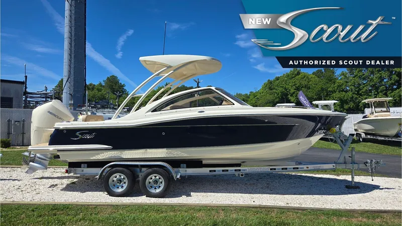 The Image of 2025 Scout 240 Dorado boat on trailer at authorized dealer, under clear blue sky. - 0