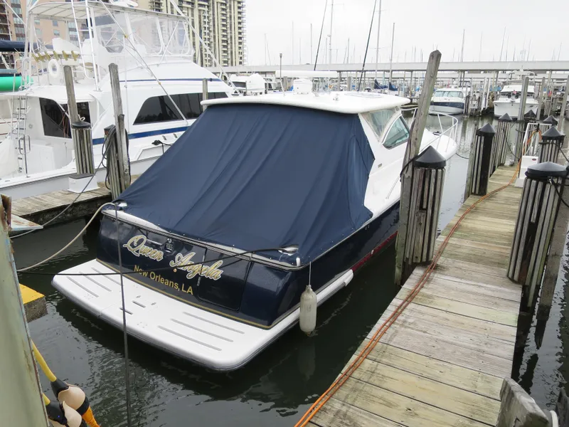 Slide: The Image of 2004 Tiara Yachts 3800 Open docked at marina with blue cover. - 1
