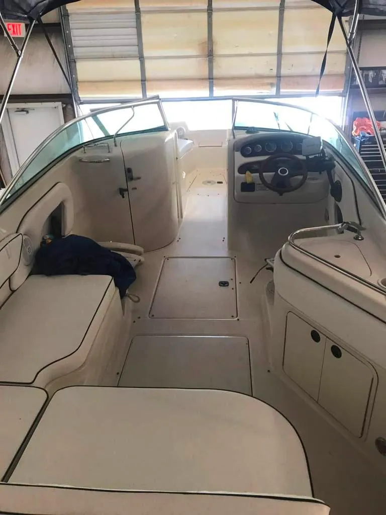 Slide: The Image of 2004 Sea Ray 240 Sundeck interior with seating and steering wheel in a garage. - 12