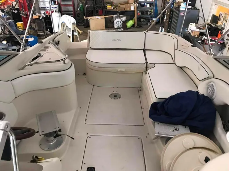 Slide: The Image of 2004 Sea Ray 240 Sundeck interior with white seating and storage compartments. - 14
