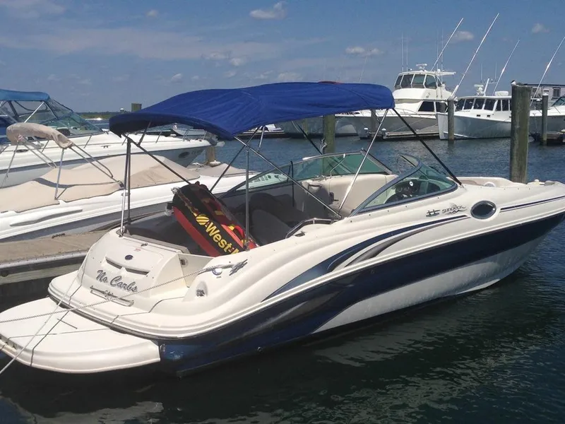 Slide: The Image of 2004 Sea Ray 240 Sundeck boat docked with blue canopy and water sports equipment. - 3