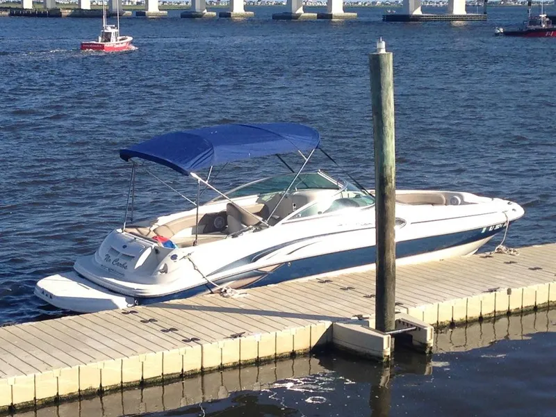 Slide: The Image of 2004 Sea Ray 240 Sundeck boat docked on a sunny day with blue canopy. - 5
