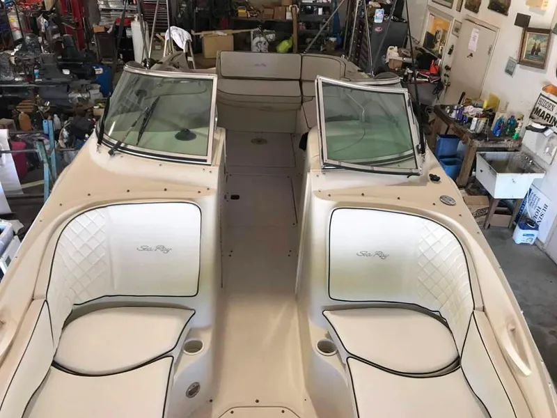 Slide: The Image of 2004 Sea Ray 240 Sundeck boat interior with spacious seating in a garage setting. - 8