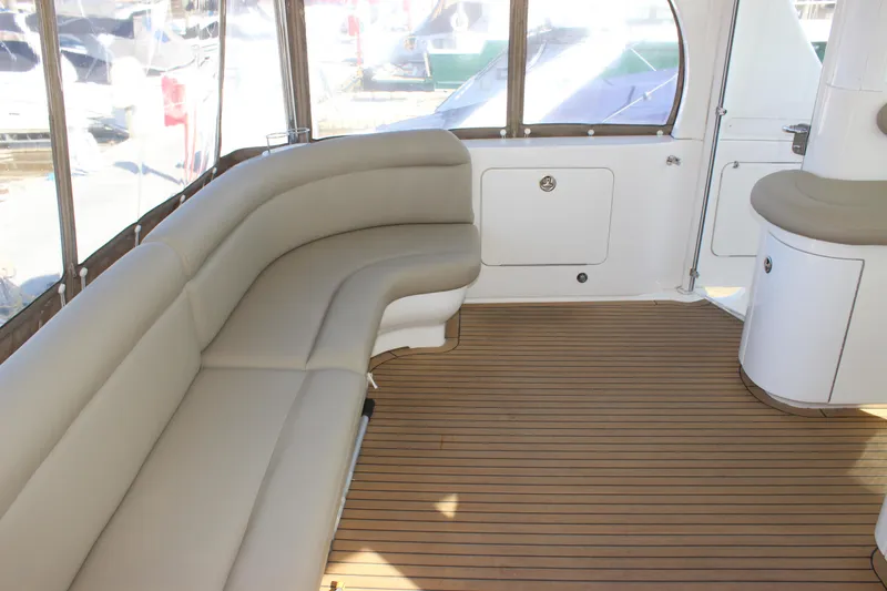 Slide: The Image of 2002 Sea Ray 480 Motor Yacht interior with beige seating and wooden flooring. - 10