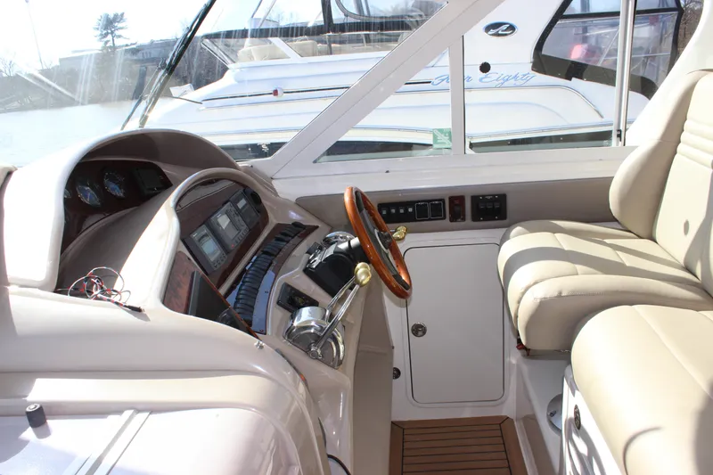 Slide: The Image of 2002 Sea Ray 480 Motor Yacht helm with leather seats and wooden steering wheel. - 24