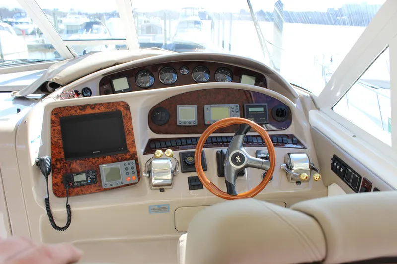 Slide: The Image of 2002 Sea Ray 480 Motor Yacht helm with advanced navigation instruments and wooden steering wheel. - 26