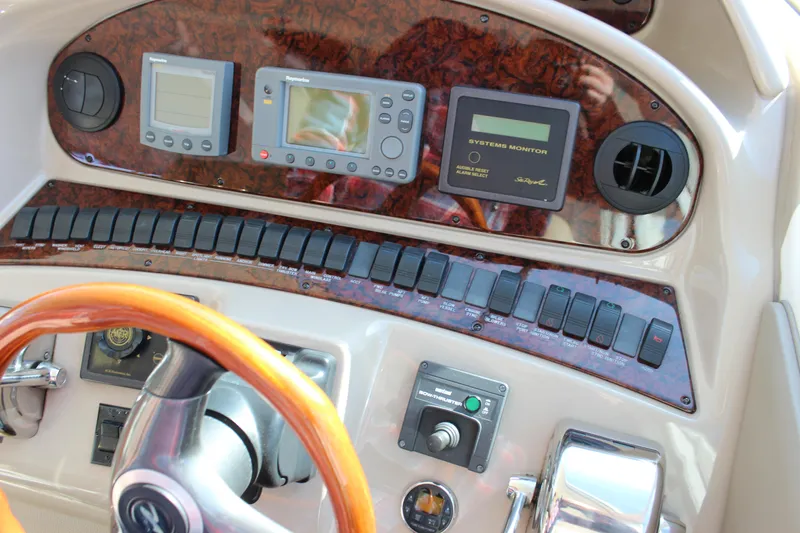 Slide: The Image of 2002 Sea Ray 480 Motor Yacht helm with navigation instruments and wooden steering wheel. - 30