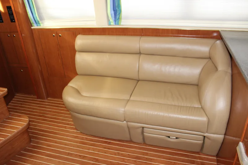 Slide: The Image of 2002 Sea Ray 480 Motor Yacht interior with beige leather sofa and wooden flooring. - 37