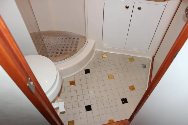Slide: The Image of 2002 Sea Ray 480 Motor Yacht bathroom with shower, toilet, and tiled floor. - 42