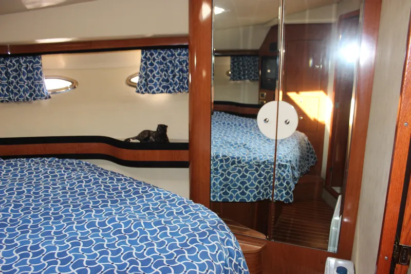 Slide: The Image of Interior cabin of 2002 Sea Ray 480 Motor Yacht with blue patterned bedding. - 48