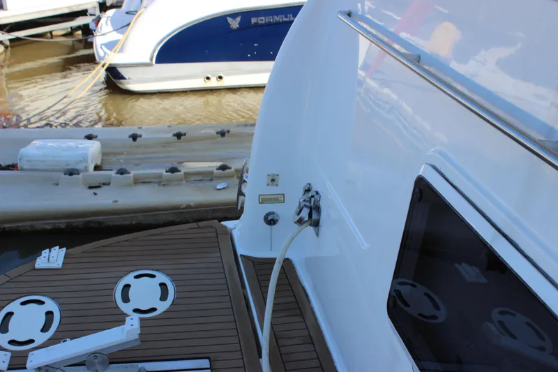 Slide: The Image of 2002 Sea Ray 480 Motor Yacht stern with dock and water hose. - 8