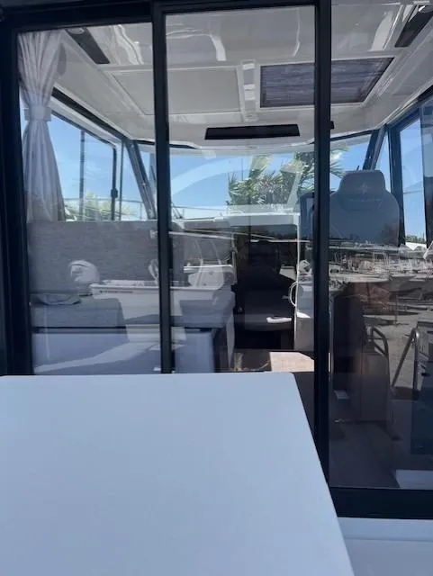 Slide: The Image of 2024 Jeanneau NC Weekender 895 interior view with seating and helm. - 1