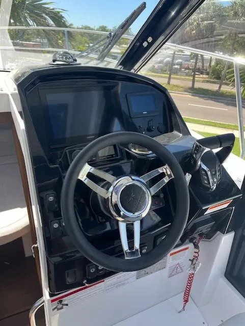 Slide: The Image of 2024 Jeanneau NC Weekender 895 helm station with modern controls and steering wheel. - 10