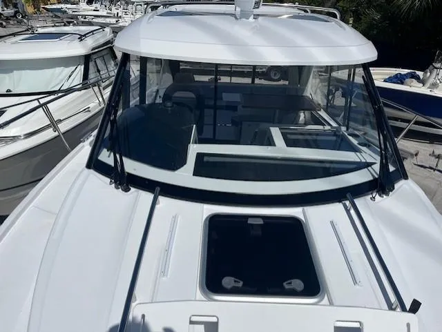 Slide: The Image of 2024 Jeanneau NC Weekender 895 boat front view with windshield and deck hatch. - 3