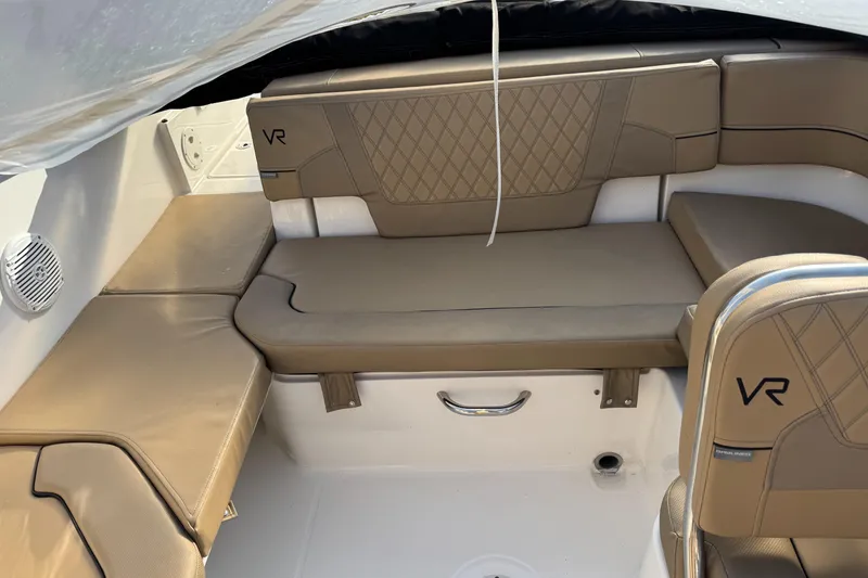 Slide: The Image of 2022 Bayliner VR 6 boat interior with tan leather seating and VR logo. - 8