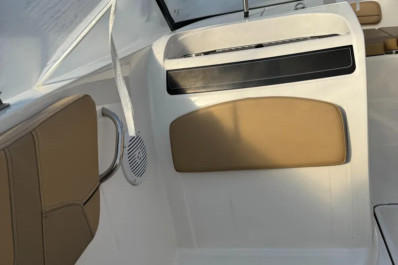 Slide: The Image of 2022 Bayliner VR 6 boat interior with tan seating and white paneling. - 9