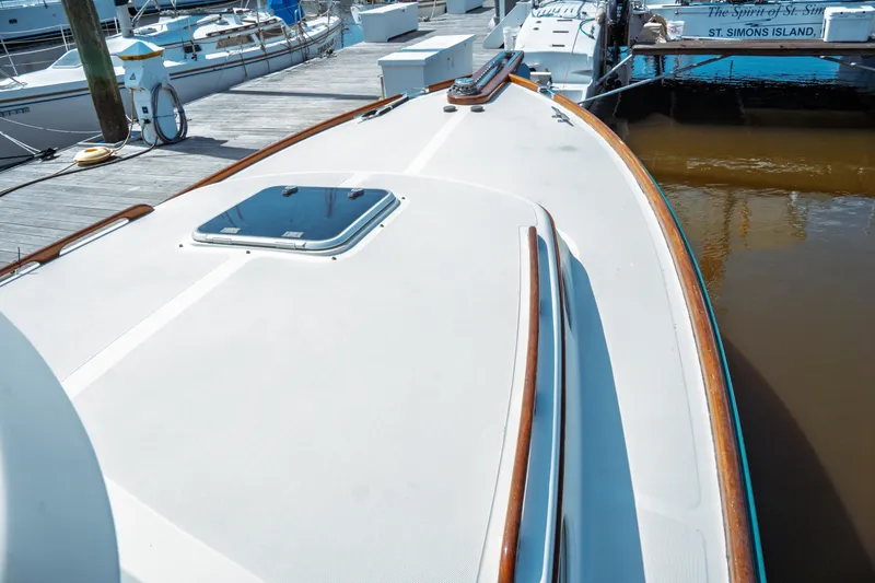 Slide: The Image of 2000 Hinckley Picnic Boat Classic docked at marina, showcasing sleek deck design. - 16