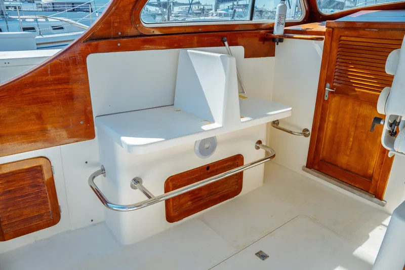 Slide: The Image of 2000 Hinckley Picnic Boat Classic interior with wooden accents and white seating area. - 22