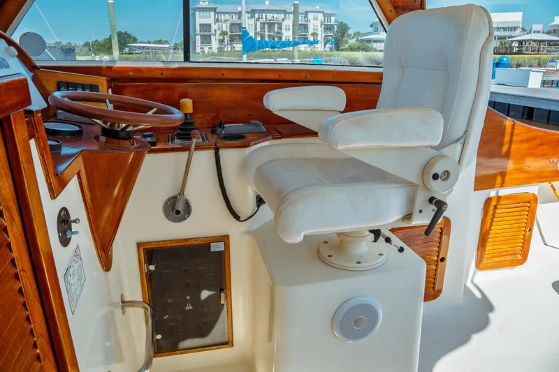 Slide: The Image of Captain's chair and helm of 2000 Hinckley Picnic Boat Classic, featuring wooden accents. - 26