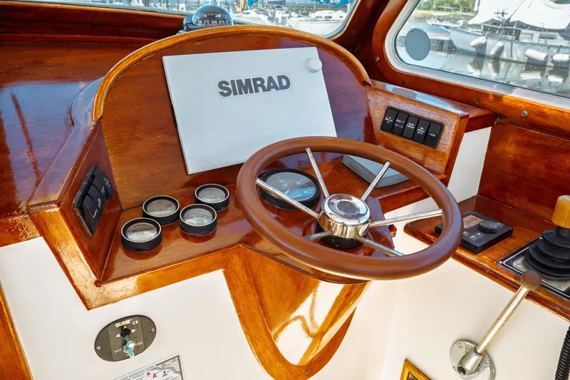 Slide: The Image of Helm of 2000 Hinckley Picnic Boat Classic with wooden steering wheel and Simrad display. - 27