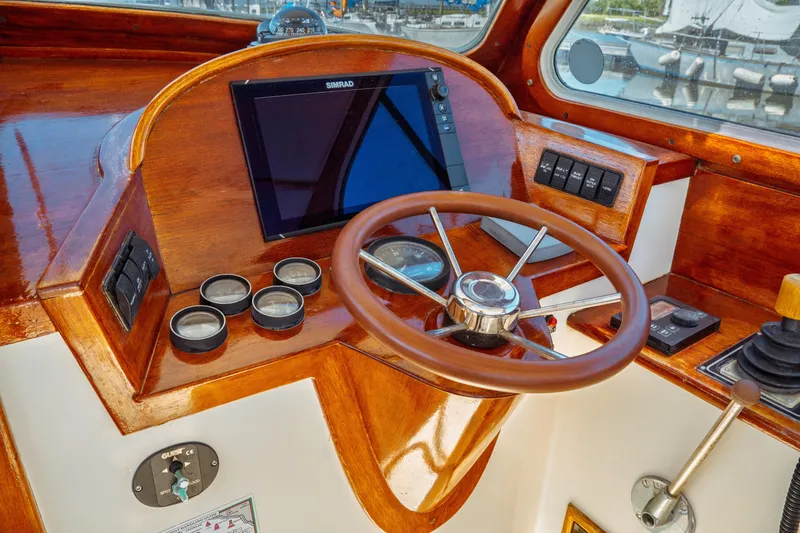 Slide: The Image of Helm of 2000 Hinckley Picnic Boat Classic with wooden steering wheel and navigation instruments. - 28