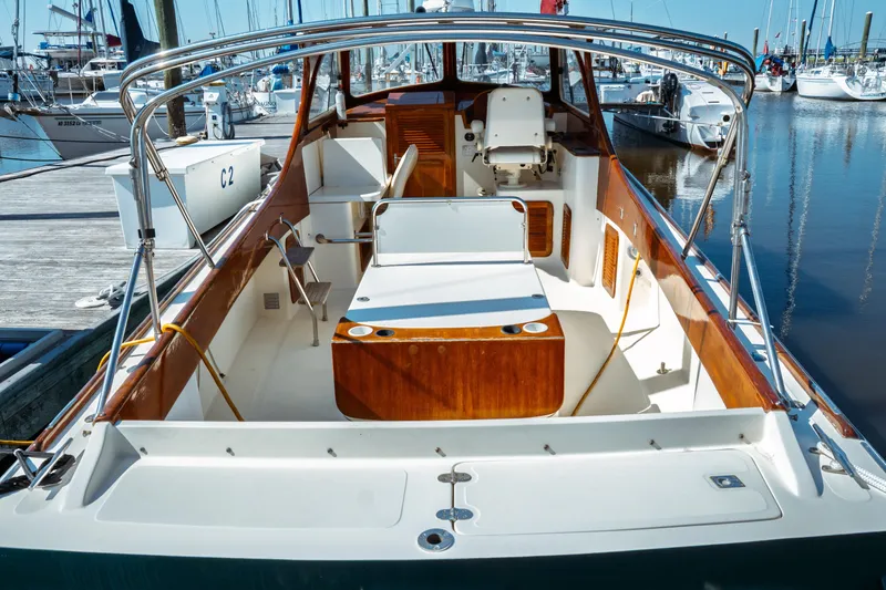 Slide: The Image of 2000 Hinckley Picnic Boat Classic docked at marina, showcasing elegant wooden interior. - 3