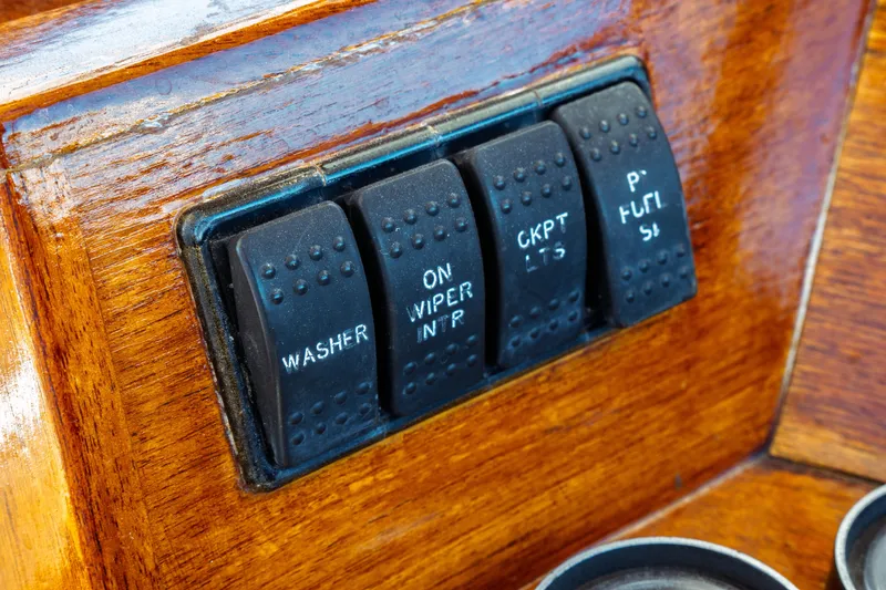Slide: The Image of Hinckley Picnic Boat Classic 2000 dashboard switches on polished wood panel. - 30