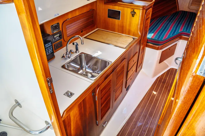 Slide: The Image of Interior of 2000 Hinckley Picnic Boat Classic with wooden cabinetry and compact kitchen area. - 42