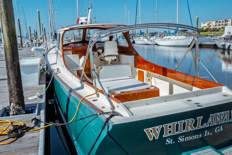 Slide: The Image of 2000 Hinckley Picnic Boat Classic docked at marina, featuring elegant design and spacious deck. - 5