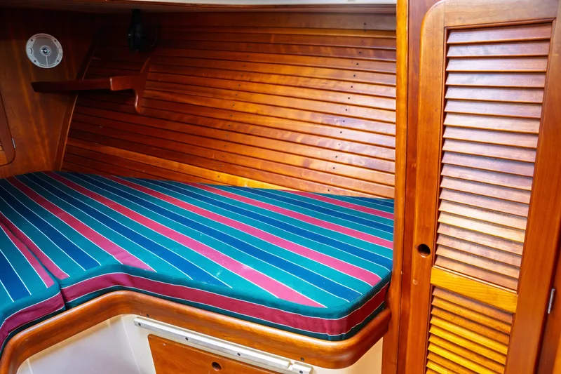 Slide: The Image of Interior of 2000 Hinckley Picnic Boat Classic with striped bedding and wooden paneling. - 59