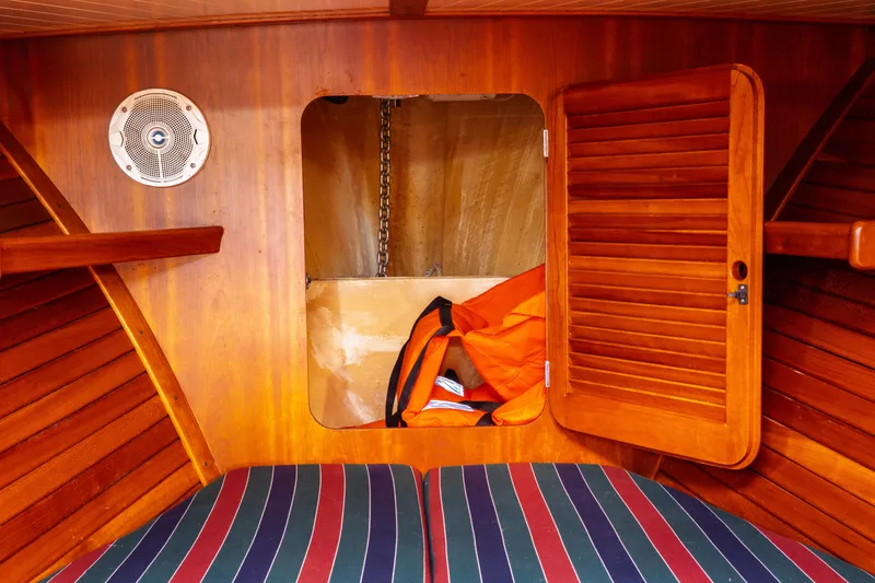 Slide: The Image of Interior of 2000 Hinckley Picnic Boat Classic with wooden paneling and striped cushions. - 60