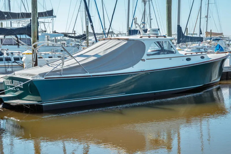 Slide: The Image of 2000 Hinckley Picnic Boat Classic docked in a marina, covered and ready for use. - 11