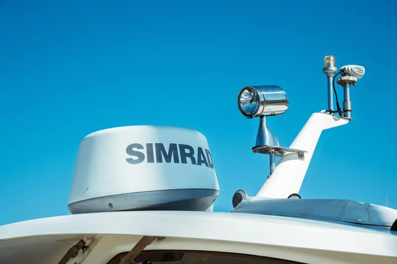 Slide: The Image of Hinckley Picnic Boat Classic 2000 with Simrad radar and spotlight against clear blue sky. - 15