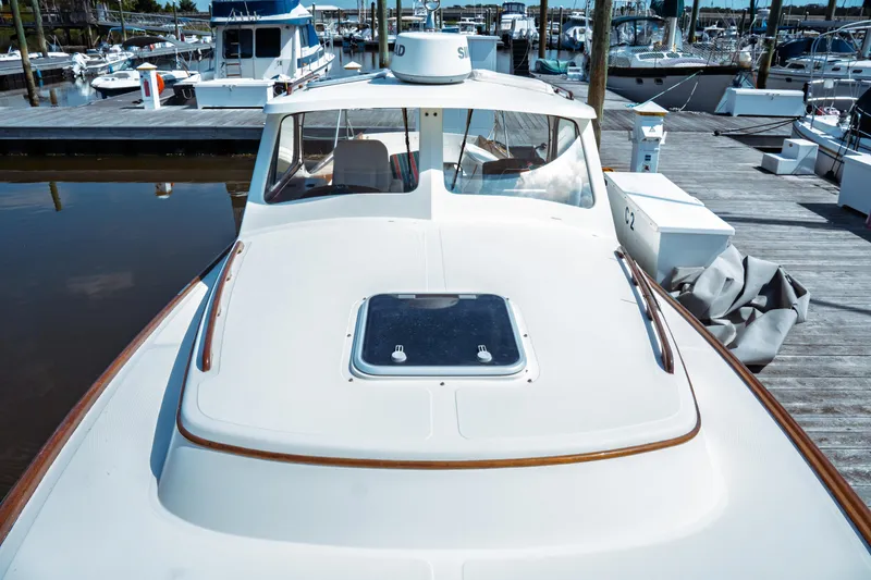 Slide: The Image of 2000 Hinckley Picnic Boat Classic docked at marina, showcasing sleek design and craftsmanship. - 19