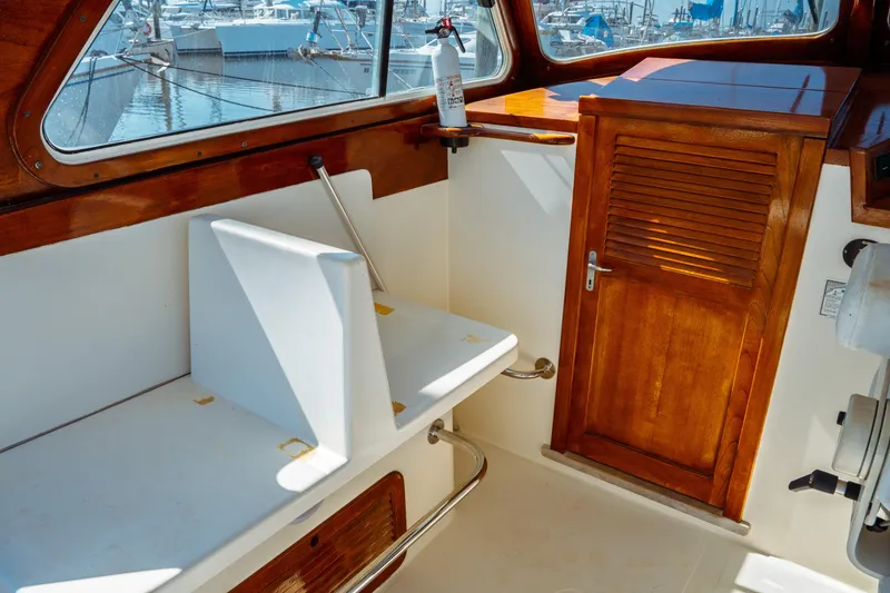 Slide: The Image of Interior of 2000 Hinckley Picnic Boat Classic with wooden door and white seating. - 23