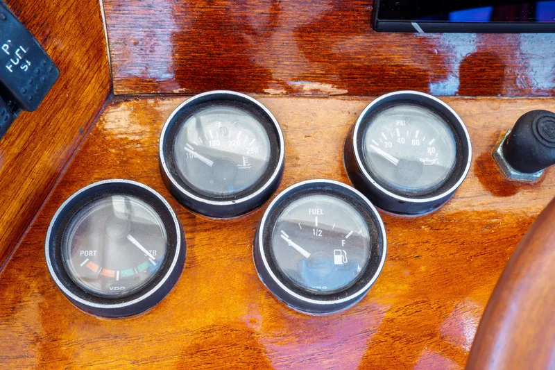 Slide: The Image of Hinckley Picnic Boat Classic 2000 dashboard with fuel and pressure gauges on wooden panel. - 31