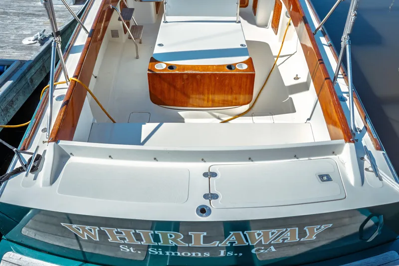 Slide: The Image of Hinckley Picnic Boat Classic 2000 docked, featuring elegant wood accents and spacious deck. - 4