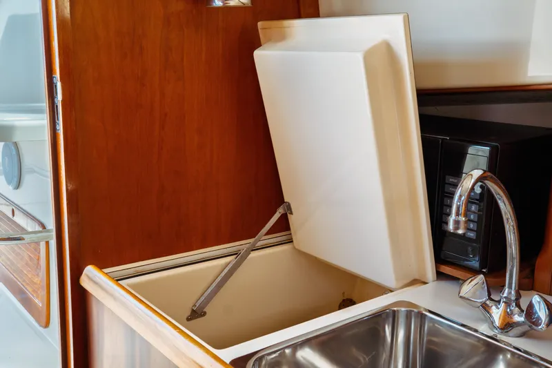 Slide: The Image of Interior of 2000 Hinckley Picnic Boat Classic with sink, microwave, and storage compartment. - 46