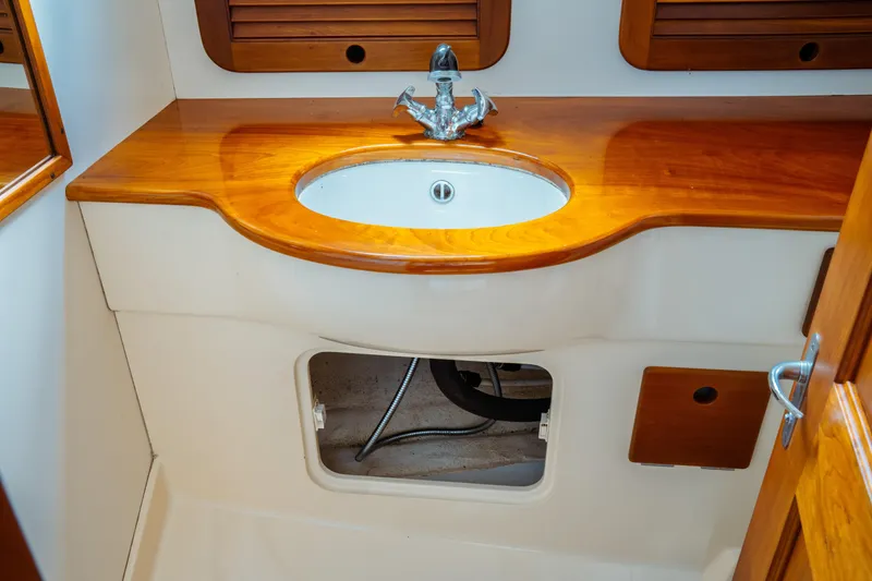 Slide: The Image of Hinckley Picnic Boat Classic 2000 interior with wooden sink and storage compartment. - 52