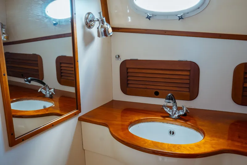 Slide: The Image of 2000 Hinckley Picnic Boat Classic bathroom with wooden accents and oval sink. - 53